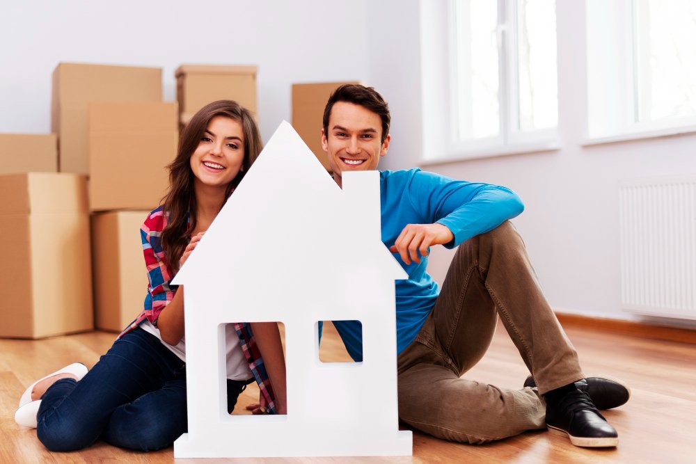 Young couple with house sign
